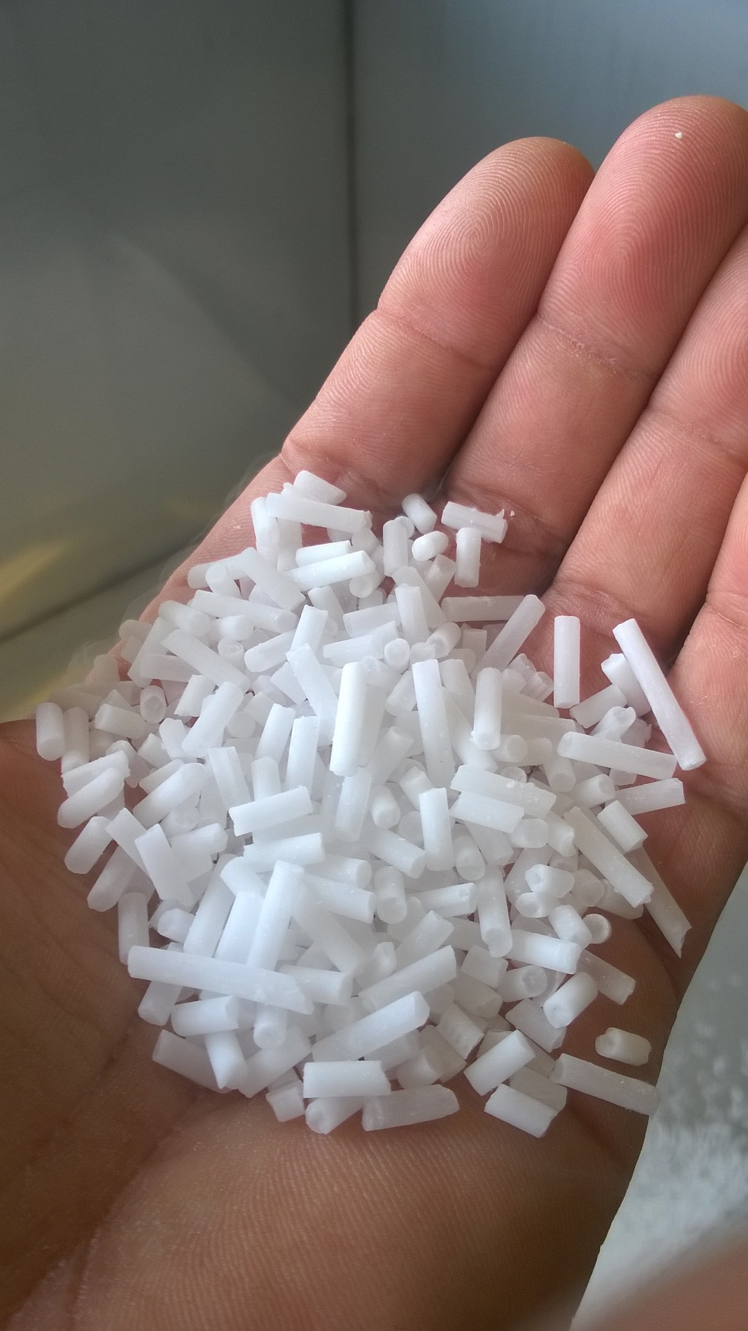 Hand holding high-density dry ice pellets produced by Dibshawaii